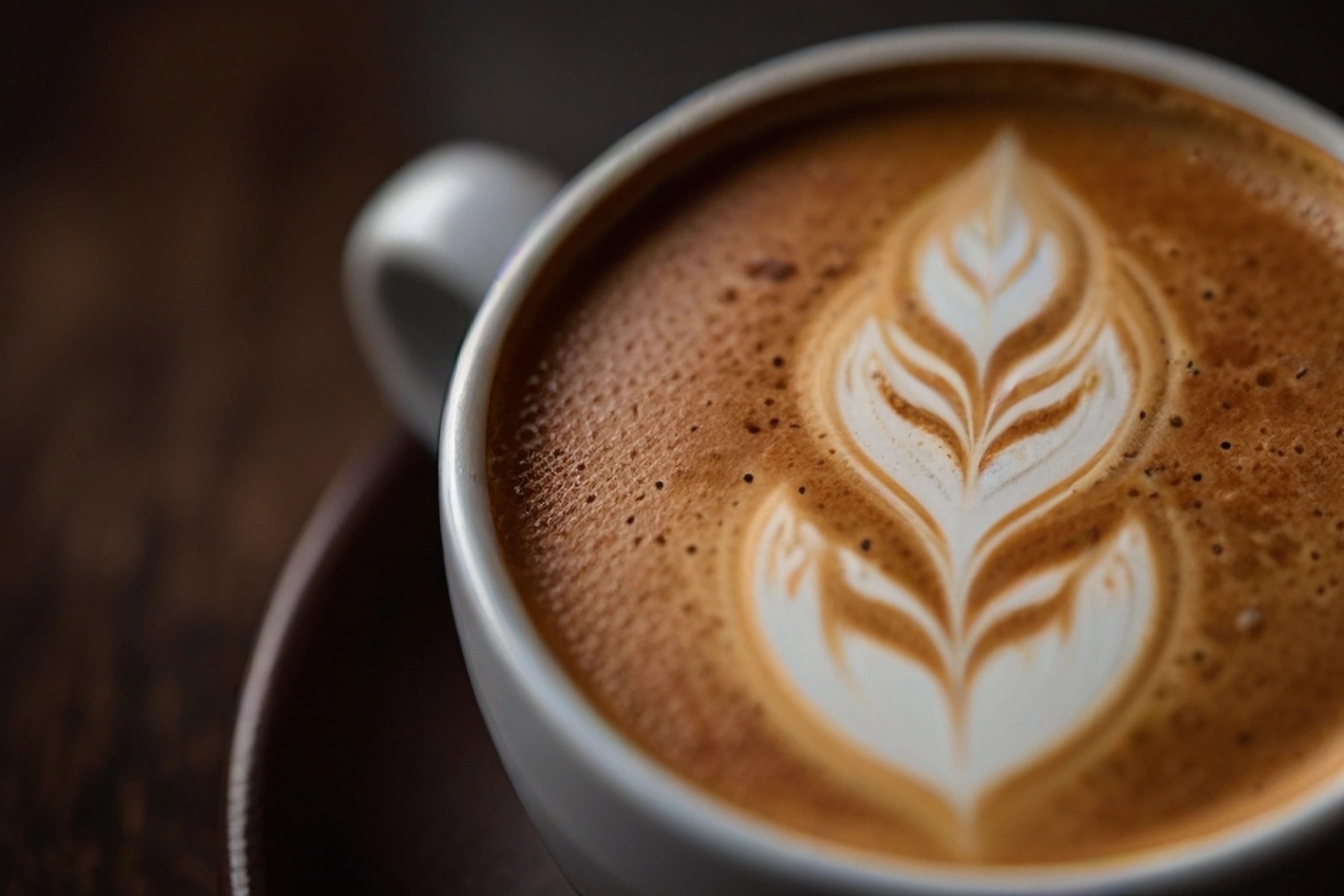 Cappuccino mit kunstvoller Latte Art in Nahaufnahme.